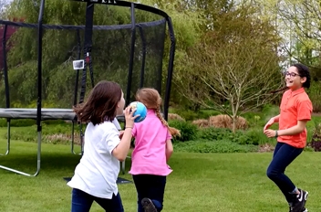 enfant qui jouent autour d'un trampoline famili